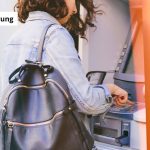 Junge Frau am Geldautomat ist von Kontosperrung betroffen